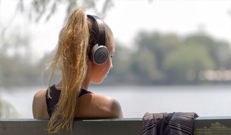 female listening outdoors with SR450 headphones